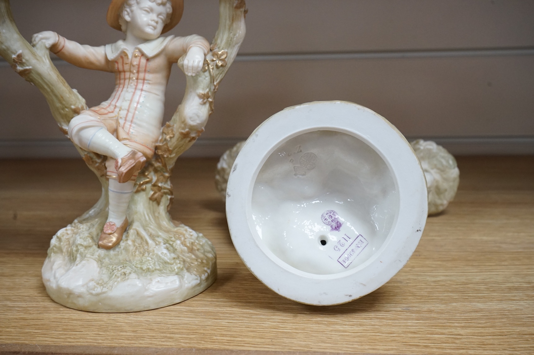 A pair of late 19th century Royal Worcester Kate Greenaway style figural two branch candelabra, modelled by James Hadley 22.5cm high
